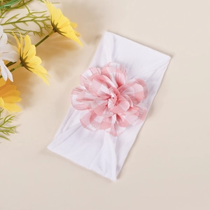 Detailed close-up of a baby nylon headband featuring a large pink and white plaid flower