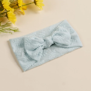 Texture détaillée d'un bandeau bébé bleu clair avec grand nœud et motifs feuilles