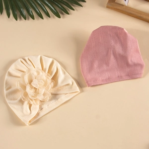 Détail de turbans pour bébé en beige avec grande fleur 3D et tricot rose poudré