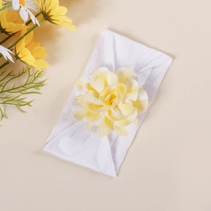Detail of baby elastic headband featuring a large yellow and white plaid bow and floral design