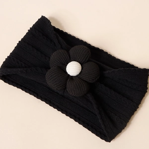Detail of black rib-knit baby headband with 3D floral accent and soft elastic texture