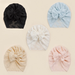 Detailed view of five-piece baby lace turban hats with large bows in soft pastel colors