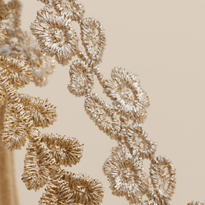 Vue macro de broderies florales dorées et argentées sur des bandeaux pour bébés