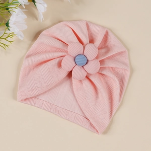 Détail du bonnet turban bébé rose côtelé avec une fleur 3D rose et bleue décorative