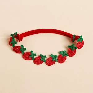 Vue détaillée du bandeau rouge pour bébé avec motif de fraise brodé de haute qualité