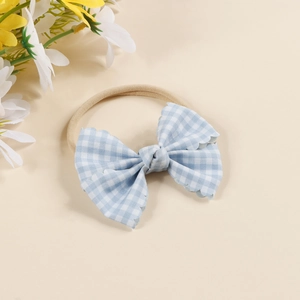 Detail of baby headband featuring light blue gingham bow on soft elastic nylon band