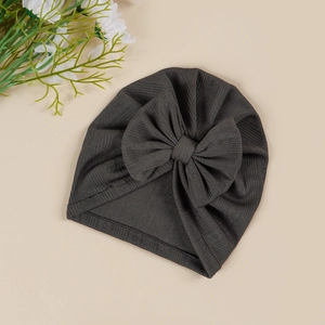 Close-up of dark grey ribbed knit baby turban hat with a large decorative bow
