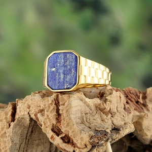 Detail of gold signet ring with rectangle lapis lazuli stone on rustic bark