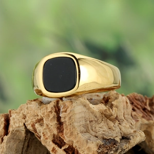 Vista macro di un intarsio in agata nera quadrata su un anello a sigillo placcato oro
