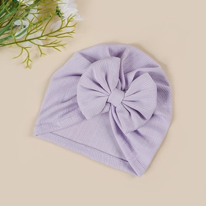 Close-up of soft lavender knitted baby turban hat with a large decorative bow