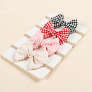 Detailed set of four elastic baby headbands with checkered bows and scalloped edges