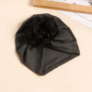 Détail d'un bonnet turban pour bébé en maille gris foncé avec une grande fleur décorative