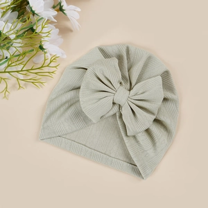 Close-up of baby turban hat in sage green with breathable jacquard knit and bow