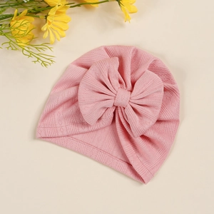 Detailed view of pink baby turban hat featuring soft pointelle knit fabric and large bow