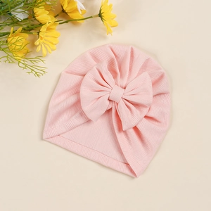 Detailed view of pink baby turban hat featuring soft jacquard fabric and a large bow