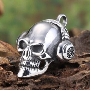 Macro view of vintage skull pendant with headphones detail on a dark wood surface