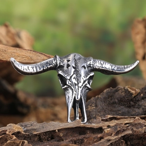 Detailed close-up of a vintage bison skull pendant with antique silver finish on wood