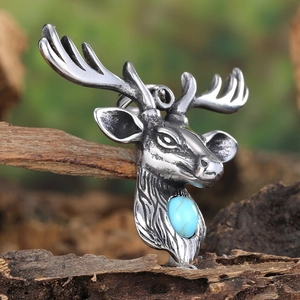 Macro detail of a punk style stainless steel stag head pendant with blue turquoise stone