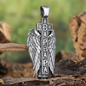 Vintage stainless steel cross pendant with angel wings on a rustic bark surface