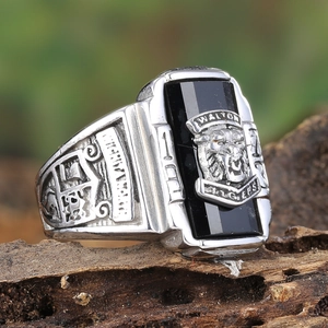 Macro shot of vintage men's silver ring with black stone and embossed tiger crest