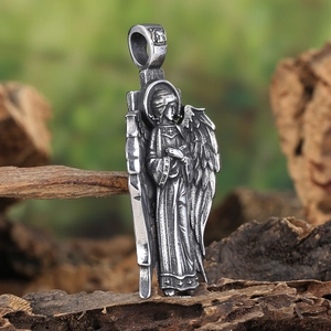 Detailed macro view of a vintage angel pendant with wings on a rustic wooden background