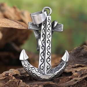 Vintage stainless steel anchor pendant with intricate scrollwork on rustic wood