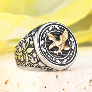 Macro shot of vintage steel ring featuring a gold eagle crest and floral engravings
