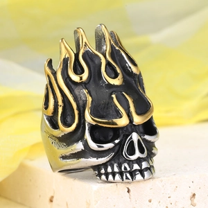 Macro detail of gothic skull ring with golden flame pattern and black enamel finish