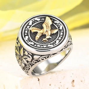 Macro shot of retro stainless steel eagle ring with gold relief and vintage textures