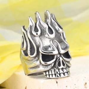 Detail of vintage skull ring with flame design and blackened steel texture finish