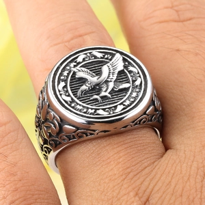 Close-up of retro eagle relief on stainless steel ring with vintage vine engravings