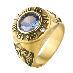 Detailed view of vintage gold ring with blue gemstone and all for one engraving