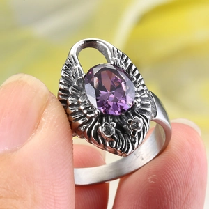 Detalle macro de anillo de águila gótica con gema púrpura ovalada y acabado vintage