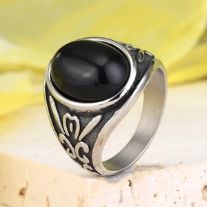 Macro detail of men's punk ring with large black oval gemstone and vintage carvings