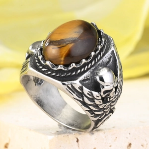 Makroaufnahme von Vintage-Edelstahlring mit Tigerauge-Stein und Totenkopf-Reliefs