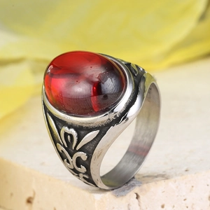 Detailed close-up of a vintage stainless steel ring featuring a large oval red gemstone