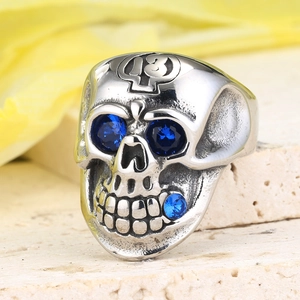 Dettaglio macro dell'anello teschio punk con occhi di zircone blu e numero 13 inciso