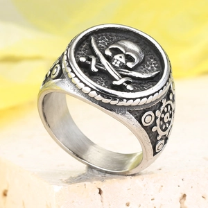 Close-up of vintage pirate skull ring with crossbones and ship wheel side carving