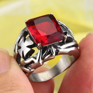 Dettaglio di un anello vintage in acciaio con zircone rosso quadrato e incisione a croce