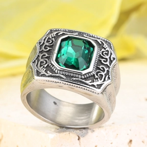 Macro di un anello vintage in acciaio al titanio con grande gemma verde e rilievo d'aquila