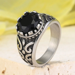 Macro detail of vintage punk stainless steel ring with crown-set round black gemstone
