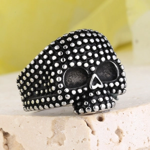 Vintage punk gothic skull ring made of stainless steel with stud details on a stone base