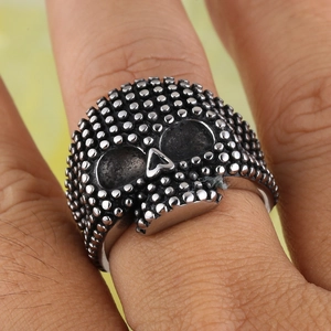 Detail of vintage punk skull ring with microbead texture on finger for men