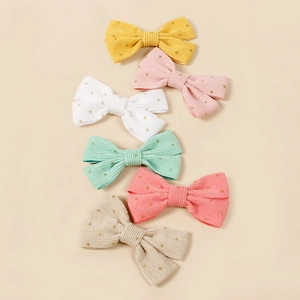 Détail de six nœuds à cheveux en velours côtelé avec pois dorés de diverses couleurs