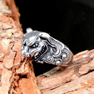 Vintage stainless steel bull head ring with intricate cloud pattern on dark wood texture