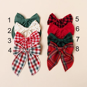 Huit barrettes de Noël en coton aux motifs à carreaux et étoiles présentées à plat