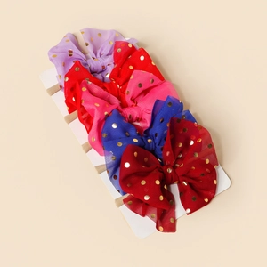 Detail of 5-piece infant headbands with gold dot mesh bows and soft nylon bands