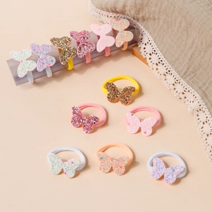 Dettaglio di elastici per capelli a farfalla con paillettes luccicanti in colori pastello