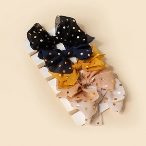 Detail of 5-piece baby headband set with gold polka dot mesh bows and nylon bands