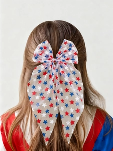 Détail d'un grand nœud à cheveux en tulle avec motif d'étoiles sur cheveux longs